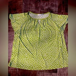 A light and bright green top with polka dots.